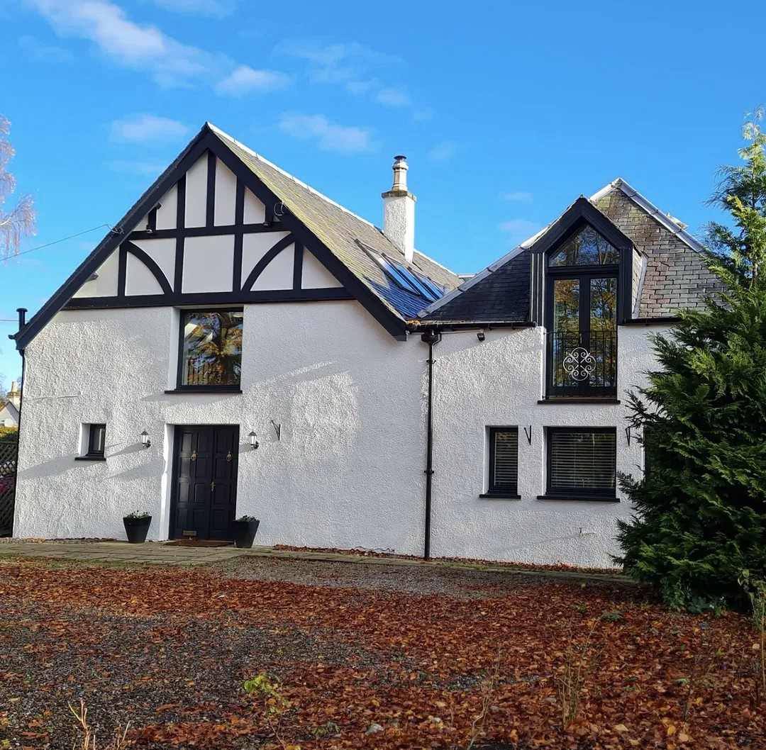 The Old Coach House front exterior under a blue autumn sky