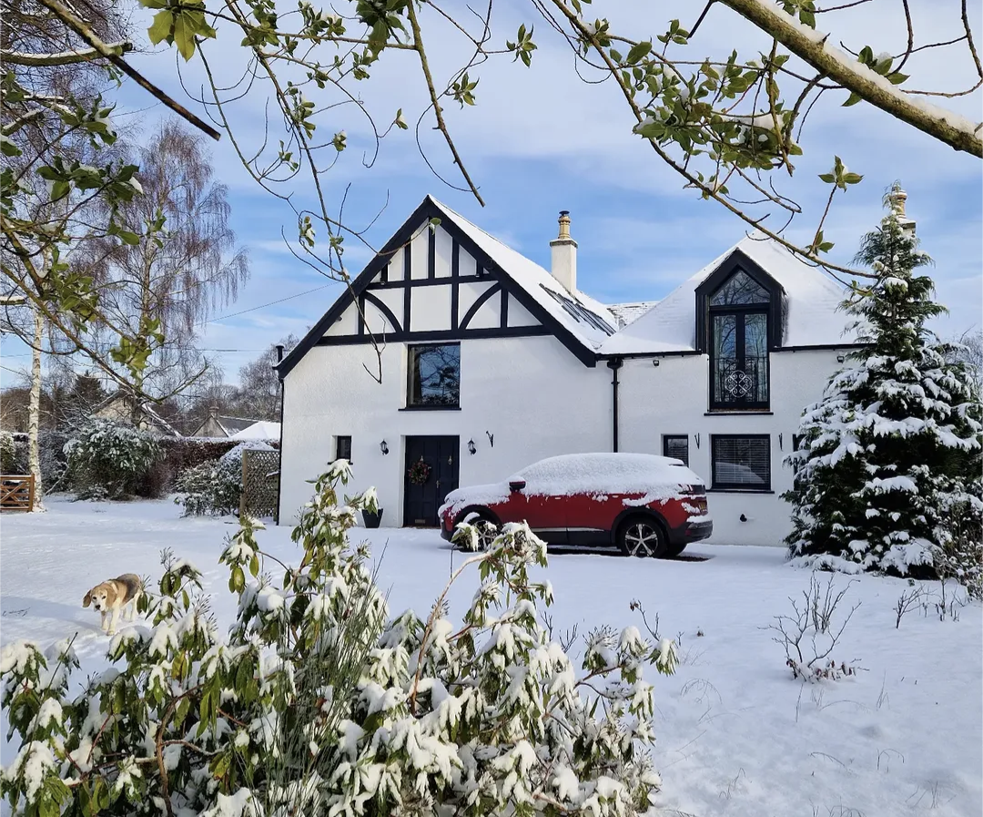The Old Coach House and its driveway covered in snow on a winter day